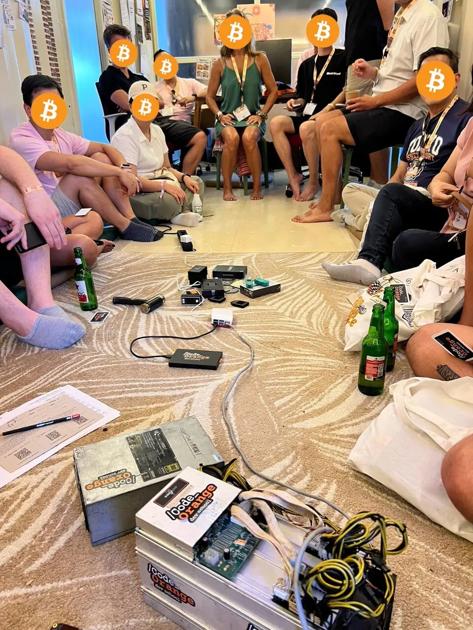 Builders sitting in a circle with Bitcoin hardware